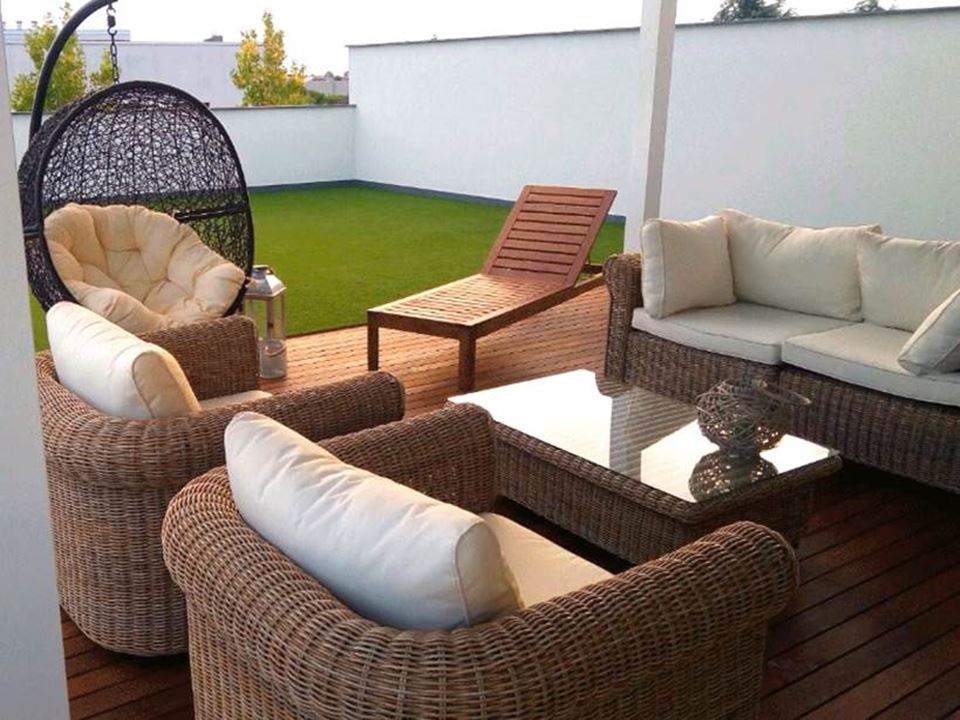 Terrazzo con salotto in rattan e prato