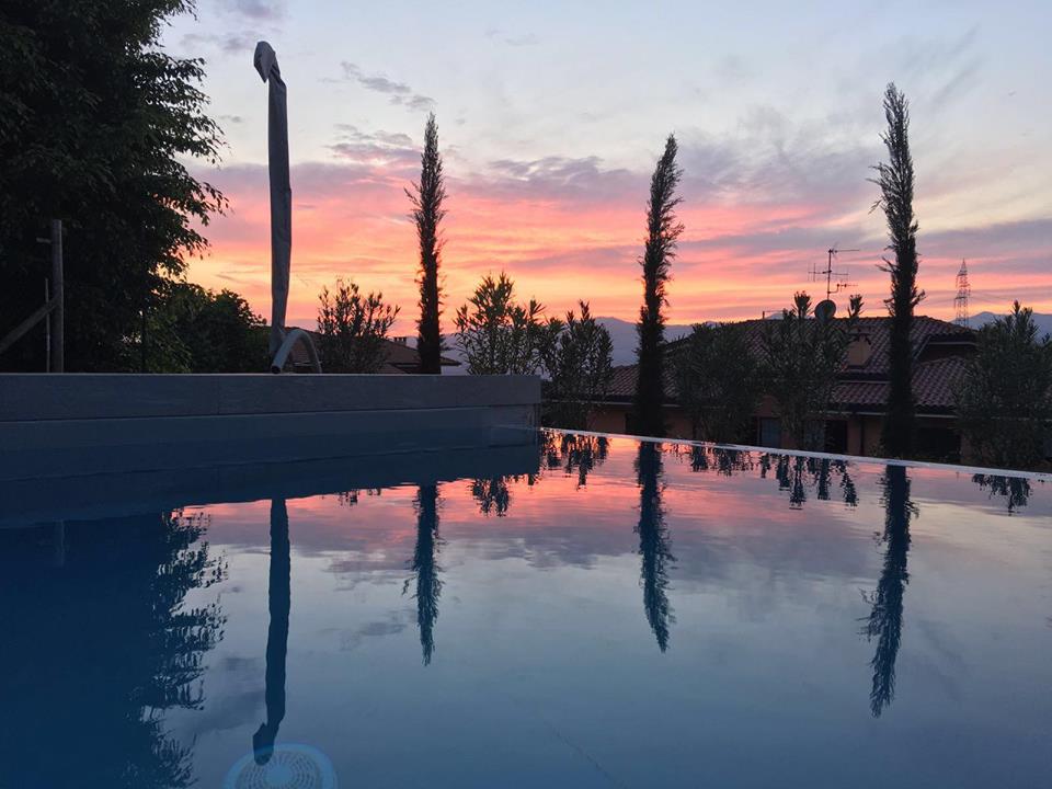 Piscina al tramonto con cipressi